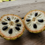 Fruta do conde cortada ao meio sobre mesa rústica de madeira